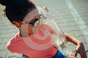 Teenager girl with skateboard spending time outdoors in city during warm summer holiday day.