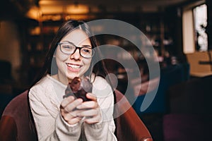 Teenager girl smiling and holding a cupcake