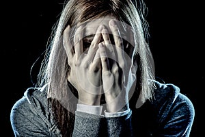 Teenager girl in stress and pain suffering depression looking sad and scared covering her face