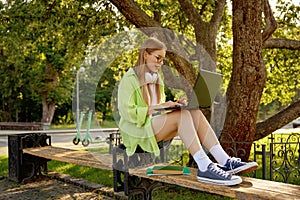 Teenager girl student doing research work using laptop computer outdoors