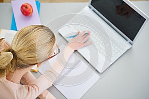 Teenager girl studying in the kitchen