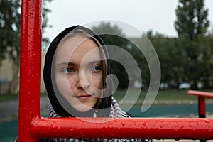 Teenager girl on a walk with a hood on her head, close up