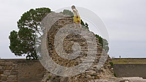 Teenager girl walking up on ruined stairs in ancient Carthage in Tunisia