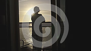 Teenager girl watching sunrise from balcony on cruise ship