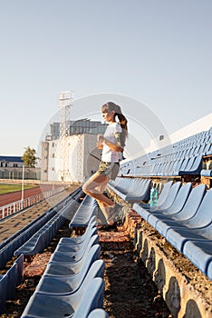 Teenager girl working out at the staduim running down the stairs