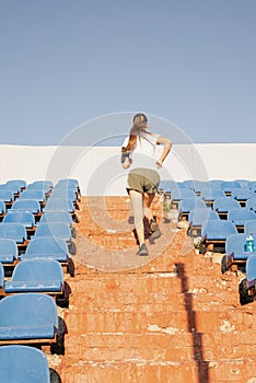 Teenager girl working out at the staduim running up the stairs