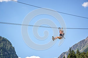 Teenager having fun on a zip line in the Alps, adventure, climbing, via ferrata during vacations in summer