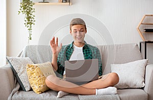 Teenager having videochat on laptop from home photo