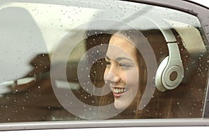 Teenager with headphones listening to the music in a car
