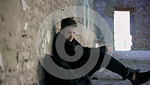 Teenager hiding from bullying in abandoned building, lonely, adolescent problems