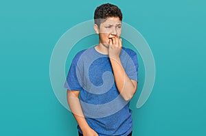 Teenager hispanic boy wearing casual clothes looking stressed and nervous with hands on mouth biting nails