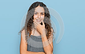 Teenager hispanic girl wearing casual clothes looking confident at the camera smiling with crossed arms and hand raised on chin