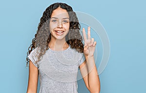 Teenager hispanic girl wearing casual clothes smiling with happy face winking at the camera doing victory sign