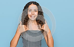 Teenager hispanic girl wearing casual clothes success sign doing positive gesture with hand, thumbs up smiling and happy