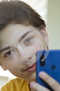 Teenager Holded in Hand Smartphone . Boy look in cell phone and take picture