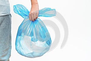 A teenager holding a big plastic bag of clothes for recycling, copy space