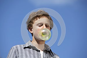 Teenager with huge chewing gum bubble