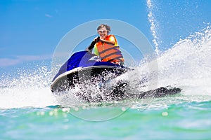 Teenager on jet ski. Teen age boy water skiing. photo