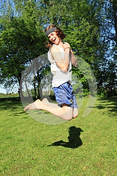 Teenager jumping on meadow