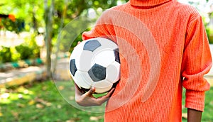 teenager kid holding football at garden with copy space - concept of aspirations, future goals and weekend holidays