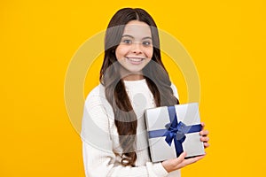 Teenager kid with present box. Teen girl giving birthday gift. Present, greeting and gifting concept. Happy face