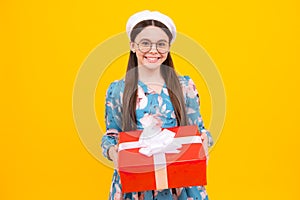 Teenager kid with present box. Teen girl giving birthday gift. Present, greeting and gifting concept. Happy teenager