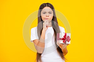 Teenager kid with present box. Teen girl giving birthday gift. Present, greeting and gifting concept. Thinking face