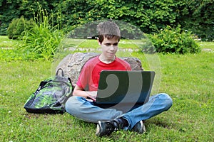 Teenager with a laptop in the park