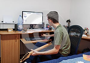 Teenager learning to play electric guitar