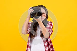 Teenager lifestyle, teen hipster hold professional camera. Girl with photo camera photographing, isolated on studio