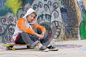 Teenager listening music near a graffiti wall