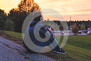 Teenager listening to music and watching the sunset.