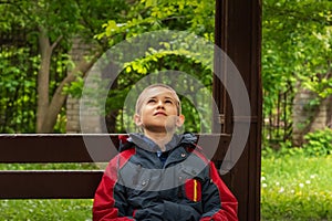 Teenager is looking up while sitting on bench