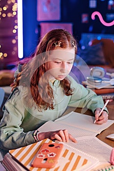 Teenager Making Notes While Doing Homework