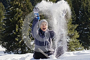 Teenager man happy play with snow in winter time wearing jacket