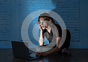 Teenager man suffering Internet cyber bullying sitting alone with computer feeling hopeless