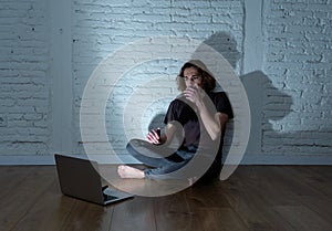 Teenager man suffering Internet cyber bullying sitting alone with computer feeling hopeless