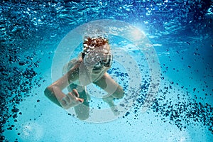 Teenager in the mask and snorkel swim underwater.