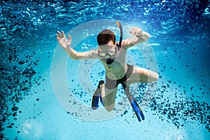 Teenager in the mask and snorkel swim underwater.