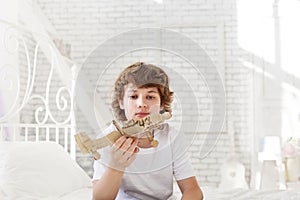Teenager with model paper airlplane in room