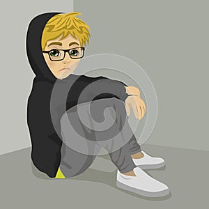 Teenager nerd boy desperate sitting on floor over grey background with dark clothes