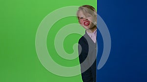 Teenager peeks out from behind and board curves of the face on a green screen