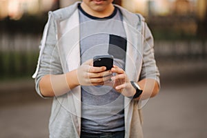 Teenager play games at mobile phone outside