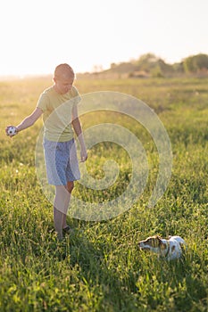 Teenager playing with a dog in the nature,