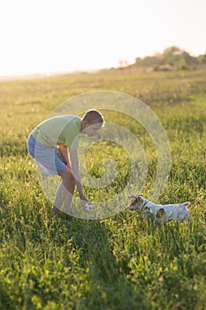 Teenager playing with a dog in the nature,