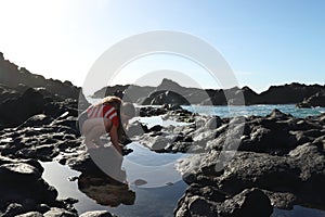 Teenager playing in the natural pools of Los Gigantes, Spain
