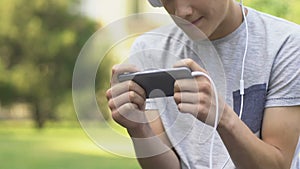 Teenager playing video game on phone, nervous and irritated, gaming disorder
