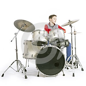 Teenager plays drums in studio with white background