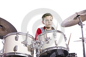 Teenager plays drums in studio with white background