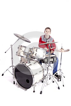 Teenager plays drums in studio with white background